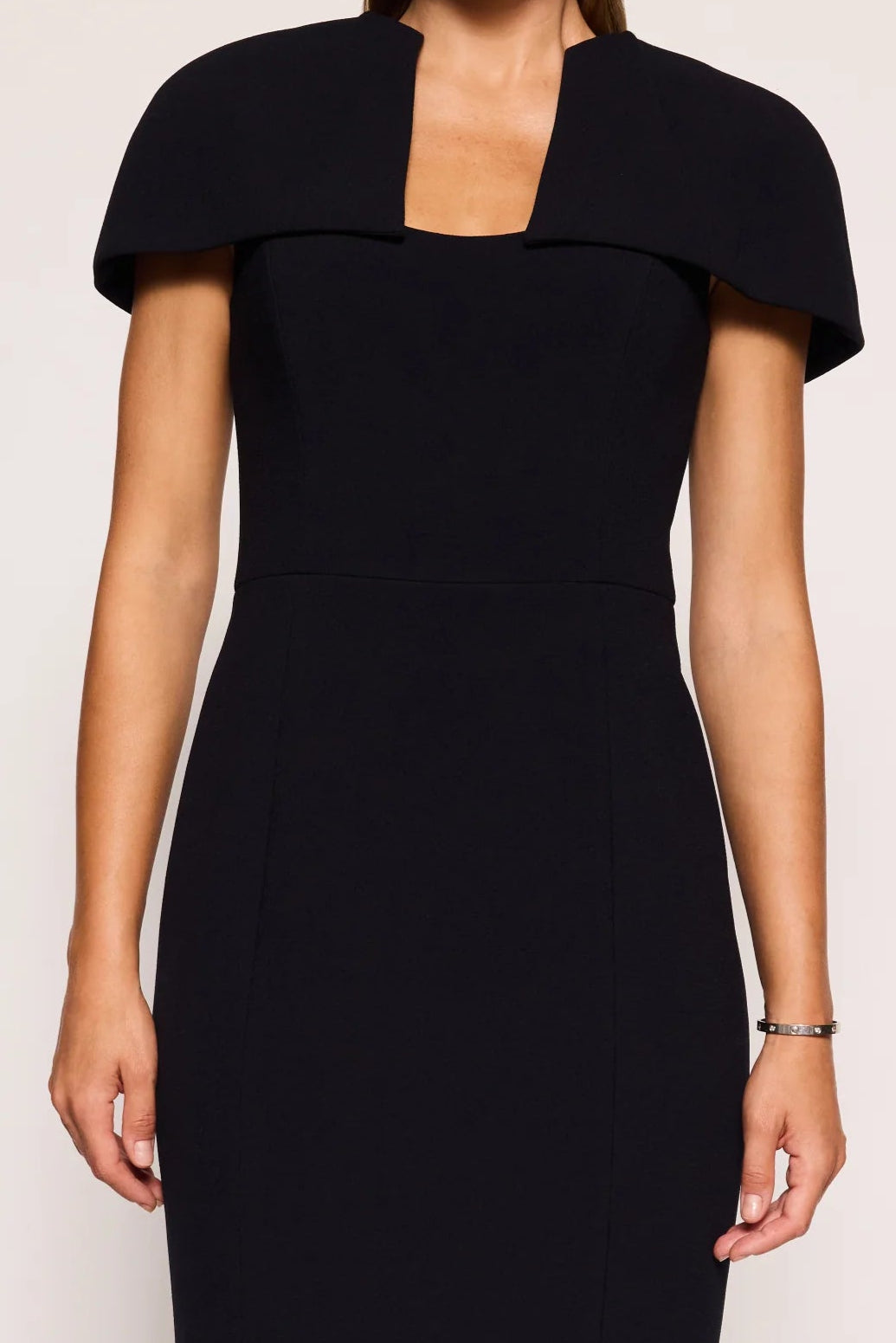 Woman wearing a black dress with a collar on a white background